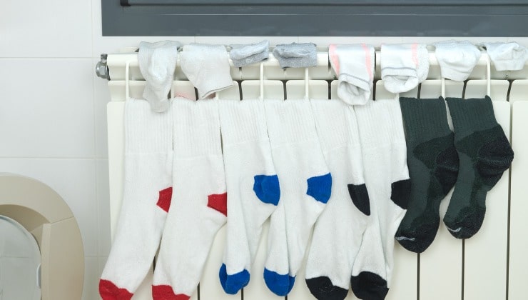 Des chaussettes colorées sèchent sur le radiateur