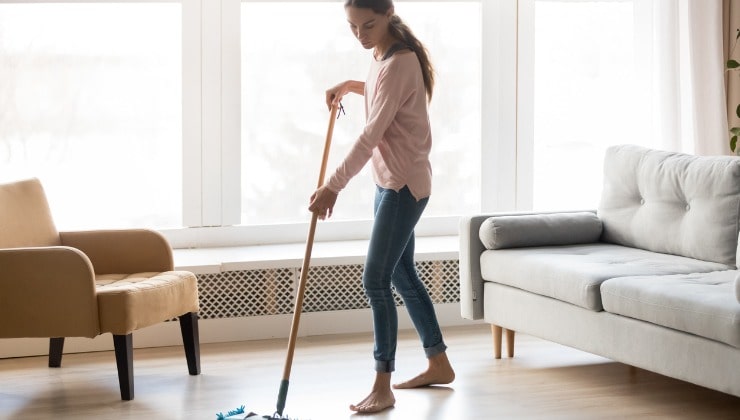 Une jeune femme nettoie le sol