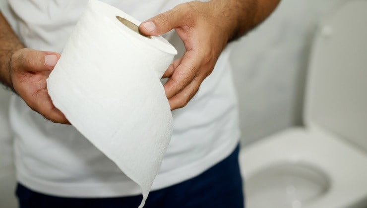 Hombre con rollo de papel higiénico en la mano