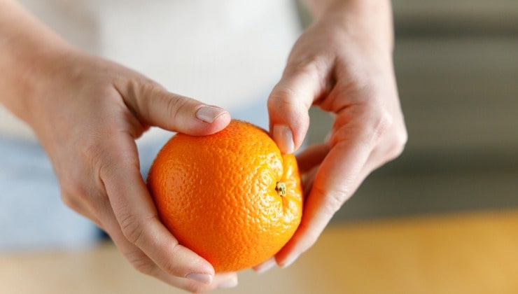 Donna sbuccia arancia