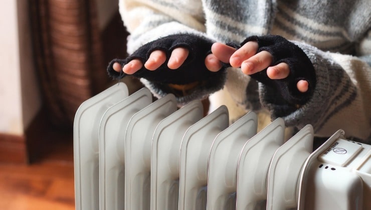 Mani si scaldano vicino al radiatore