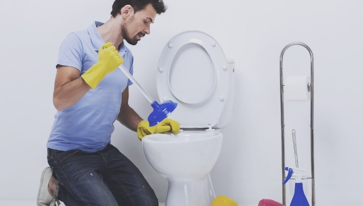 Un homme débouche les toilettes