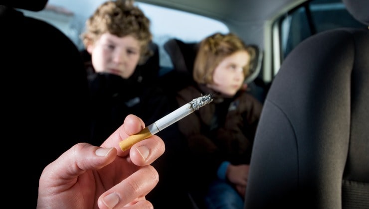 Bambini in auto con fumatore