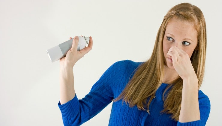 Donna spruzza deodorante in casa
