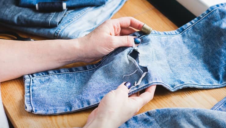 Mujer repara agujero en jeans