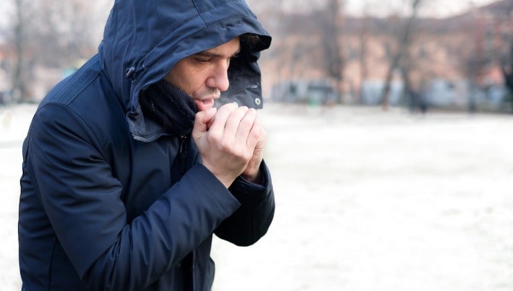 Uomo scalda le mani al freddo