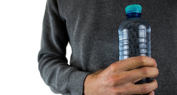 Uomo con una bottiglia di plastica in mano