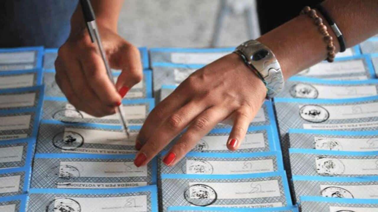 Scrutatore firma le schede elettorali