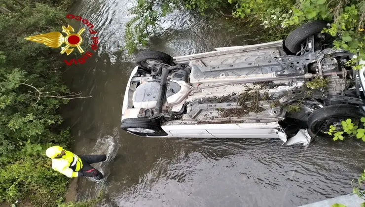 Vigili del fuoco vicino all'auto ribaltata